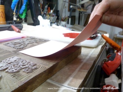 lifting the paper from the linoleum block