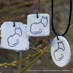 Three clay pendants.
